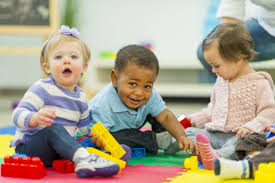 Smiling toddlers playingn with blocks